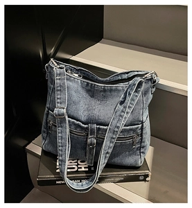 Close-up of retro denim shoulder bag with metal zipper on minimalist industrial stairs