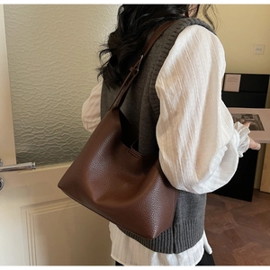 Detail of soft brown pebble leather shoulder bag showing texture and slouchy hobo design