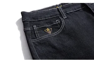 Detail view of denim jeans pocket with contrasting white stitching and embroidered logo