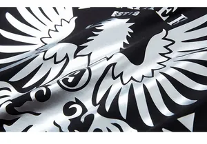 Detail of silver eagle metallic print on premium black cotton t-shirt with fine texture