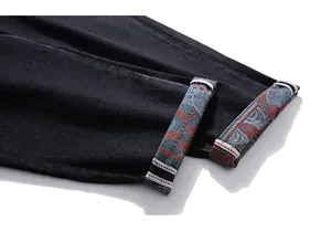 Detailed macro view of black denim jeans cuff with ethnic geometric pattern lining