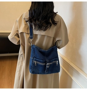 Detail of vintage blue denim tote bag with double zippers and adjustable wide strap