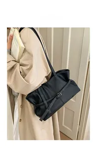 Close-up of black litchi pattern leather tote bag with stylish metal eyelet buckle detail