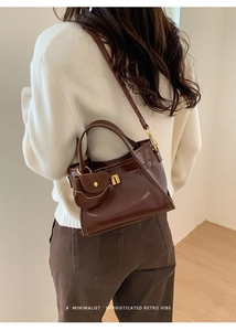 Detail of vintage dark brown tote bag with mini pouch charm and adjustable shoulder strap