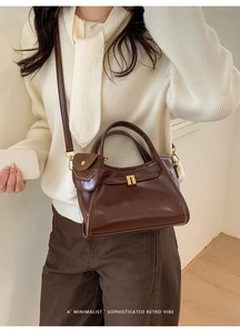 Detail of retro dark brown leather tote with hanging mini pouch and metal snap button