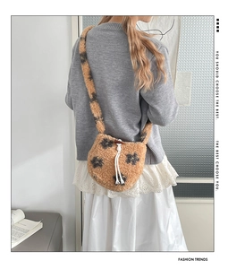 Detail of plush leopard print crossbody bag with drawstring closure and toggle button