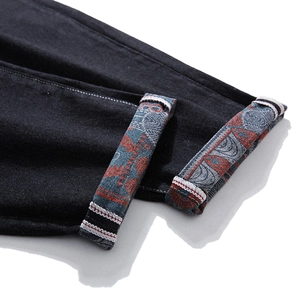 Men's loose straight leg black denim jeans with ethnic print detail on rolled cuffs
