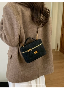 Detail of black matte suede mini square bag with golden hardware and chain strap