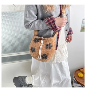 Détail du sac bandoulière en peluche marron avec motif étoile et bouton en corne