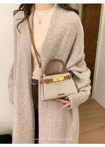 Detail view of a vintage trapezoid beige canvas and brown leather crossbody bag