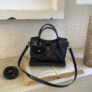 Detail of black faux leather tote with vintage hardware and matching coin purse charm