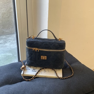 Close-up of navy blue quilted velvet mini square bag with golden chain and clasp