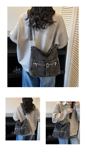 Macro detail of washed grey denim crossbody bag featuring vintage zippers and strap details