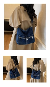 Detail view of denim tote bag with multiple zipper pockets and metal buckles