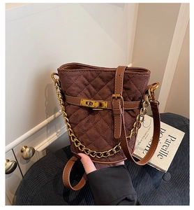 Détail du sac seau en daim matelassé marron foncé avec fermoir doré et chaînette