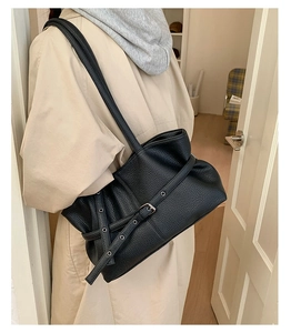 Side view of black lychee grain tote bag with belt buckle detail and long shoulder straps