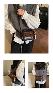 Détail d'un sac à main vintage marron foncé avec pompon et boucle dorée