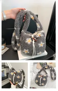 Detail view of grey plush bucket bag with daisy patterns and horn buckle closure