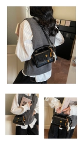 Détail du sac à main rétro en cuir noir avec fermoir doré et pampille de perles