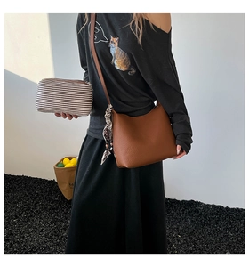 Detail of brown litchi grain leather hobo bag with a striped pouch set for women