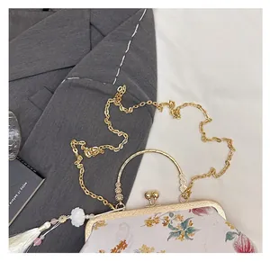 Detail of Chinese style embroidery clutch with golden ring handle and silk tassel