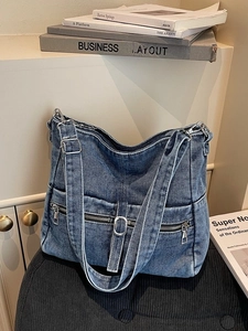 Vintage washed blue denim tote bag with functional zipper pockets and adjustable strap