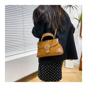 Detail showing high-capacity leopard print crossbody bag with golden buckle and leather strap
