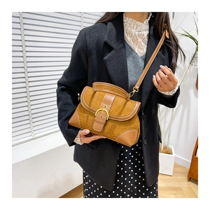 Detail shot of leopard print handbag with gold buckle, styled on a model in a black suit
