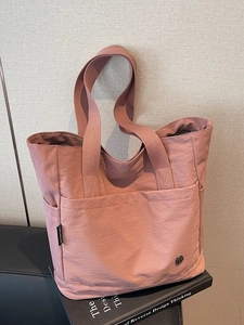 Minimalist dusky pink nylon tote bag with large front pocket and spacious interior