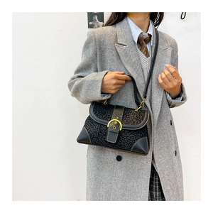 Detail of retro leopard print handbag with golden metal buckle and leather stitching