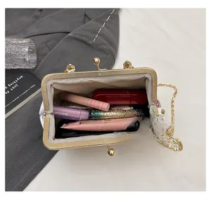 Top view of cream embroidered kiss-lock bag showing capacity for lipstick and makeup