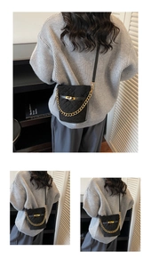 Vue détaillée du sac seau noir matelassé avec chaîne dorée et bandoulière porté par un mannequin