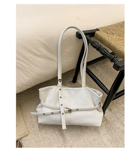 Detail of off-white lychee grain tote bag showing adjustable belt with metal buckle