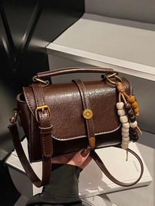 Sac bandoulière vintage marron foncé avec détails dorés et breloque perlée