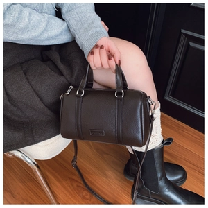 Close-up of brown litchi pattern leather Boston bag with CRHEKA logo and silver hardware