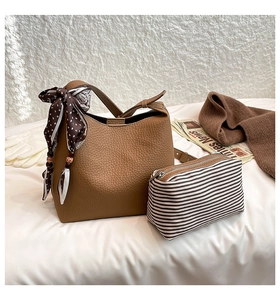 Detailed view of brown tote bag with silk scarf and striped pouch for women