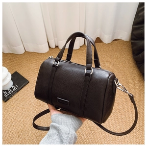Detail of lychee pattern leather boston bag with silver metal buckles and straps