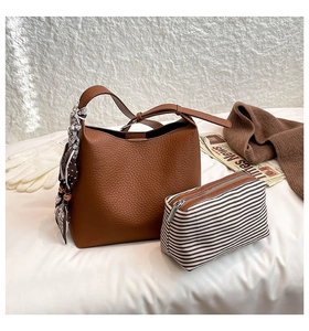 Detail of brown litchi leather hobo bag with floral scarf and striped clutch insert