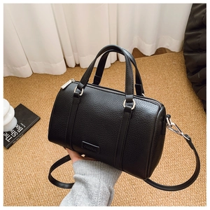 Detail of black pebbled leather Boston bag with silver hardware and CG.HEKA brand logo
