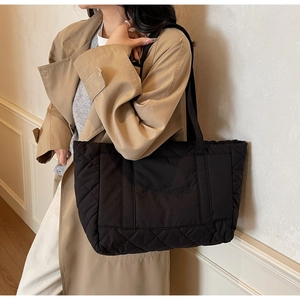 Close-up of black quilted tote bag featuring a high-capacity design and elegant embroidery