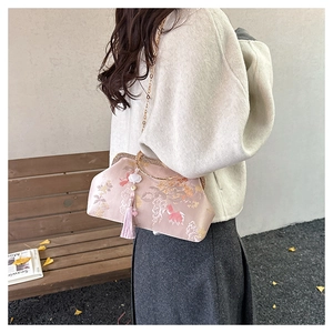 Detail of pink embroidered silk qipao bag with long tassel and golden chain strap
