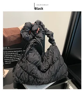 Detail of black pleated nylon cloud bag featuring a quilted texture and ruffled handle