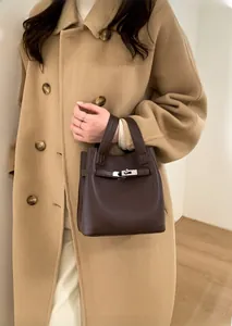 Detailed view of dark brown pebbled leather bucket bag with metallic lock closure
