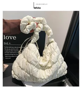 Detail of white quilted nylon cloud bag with soft pleated handle and puffy texture