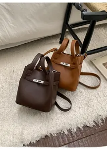 Close-up of stylish bucket bags in dark brown and caramel leather with metal locks
