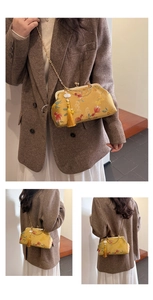 Detail of yellow silk embroidery bag featuring floral patterns and a silk tassel charm