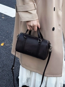 Dark brown pebble leather Boston bag featuring top handles and adjustable shoulder strap