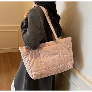Detail of pink quilted tote bag with diamond pattern and soft shoulder strap embroidery