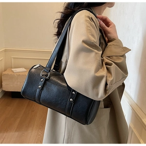 Detail of vintage black oil wax leather boston bag with silver hardware on a model