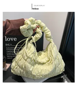 Detail of light yellow nylon cloud bag with pleated texture and ruched handle design